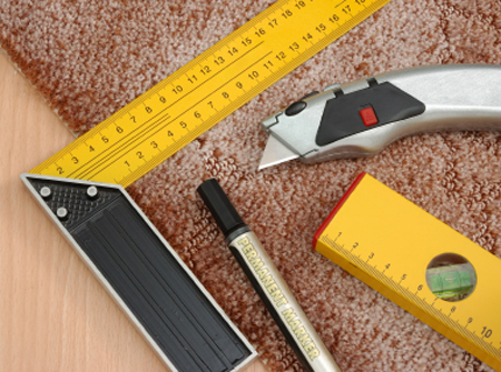 Piece of carpet with measuring square, marker and utility knife