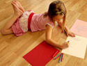 young girl drawing on laminate floor