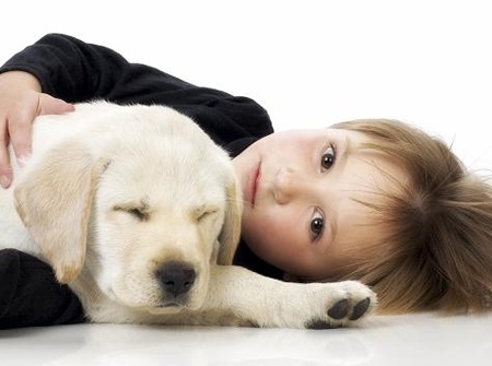 child laying on floor with puppy